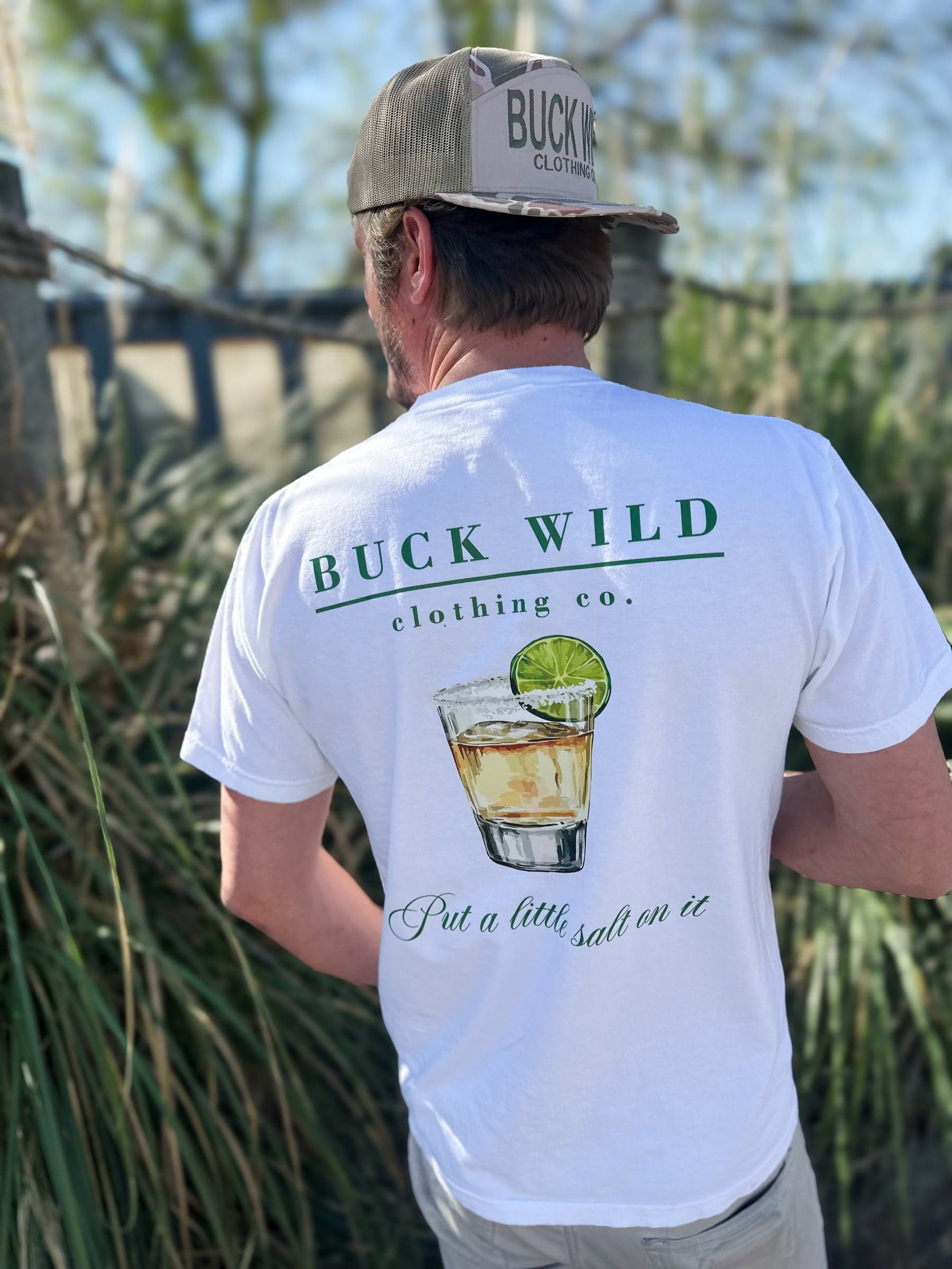Friends in Buck Wild tees, out on the water at golden hour